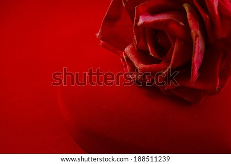 Heart's shape red velvet box with rose on red background