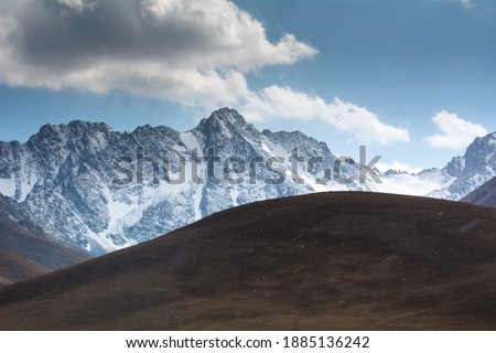 Snowy mountain peaks among the clouds, Kyrgyz ridge, Chonkurchak tract, country Kyrgyzstan. Selective focus