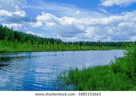 Blue sky and white clouds are reflected in the water. Beautiful landscape of nature. Wallpaper for PC desktop.