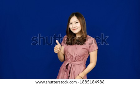 beautiful asian woman ok gesture isolated blue background