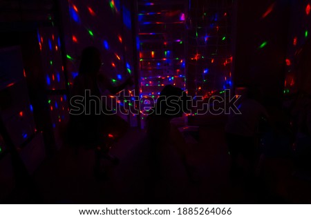 children dicso at home with   bright lights at night,  background lights with silhouettes of a children, celebration new year 