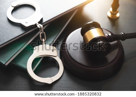 Handcuffs and wooden gavel. Crime and violence concept. Royalty-Free Stock Photo #1885320832