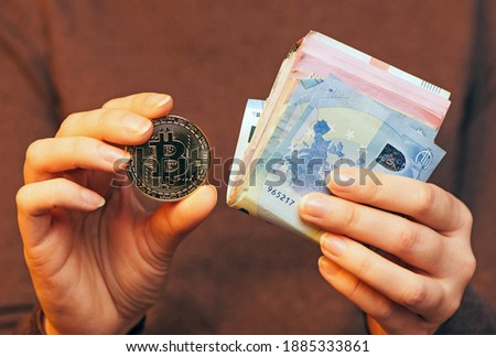 Financial concept, Make money online, selling goods online through the Internet concept. Hands are holding a stack of money and bitcoin. close up