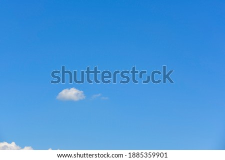 Small, fluffy and lonely clouds in the blue sky with copy space.