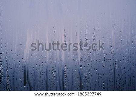 Drops of water on the sweaty glass with a blue tint. Background. Royalty-Free Stock Photo #1885397749