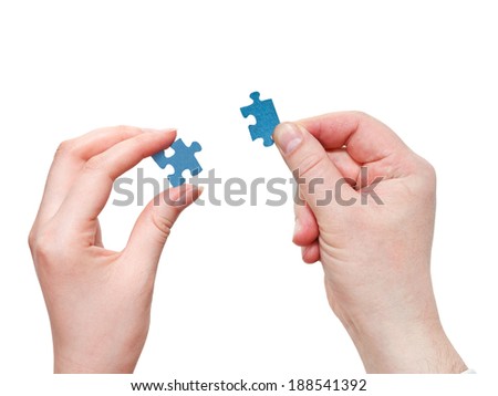 couple of male and female hands holding little puzzle pieces isolated on white background