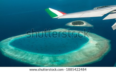 Fantastic Maldivian atolls appear in the porthole of the plane arriving at Male airport in the Maldives.