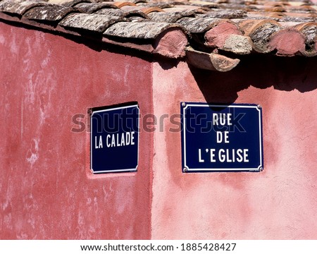 Two French street signs at the corner of the Church street and the Calade street