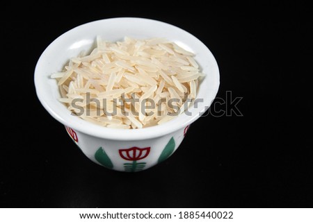 white rice in a plate on a black background, macro photograph.