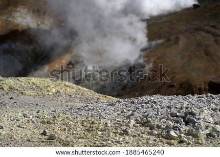 Mutnovsky volcano. Yellow spots of sulfur on gray ground. Steaming fumaroles in the crater of the active volcano. Archive photo, 2008