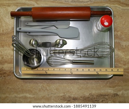 Baking tools and gadgets on top of a baking sheet ready for use.