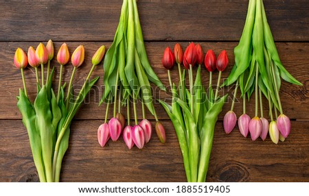 Tulips of different colors on wooden table, copy space
