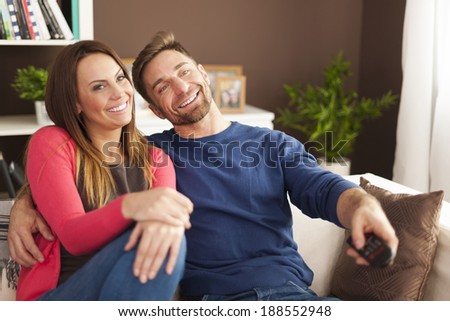 Happy couple watching tv at home 
