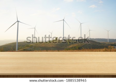 Empty wooden board table with blurred background Brown wood in blurred view, mountain landscape and windmill fields - can be used to display or edit your products, simulate to showcase them.
