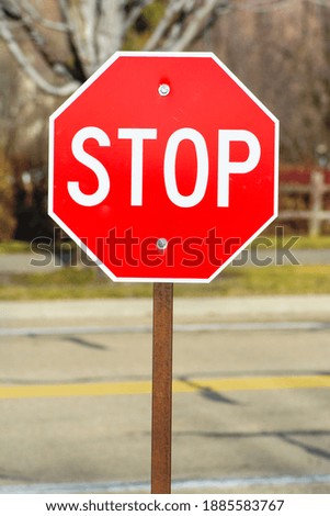 A stop sign in front of a road outdoors.
