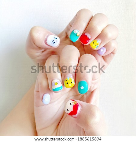 Hands with cute nail painted cartoon design. A new raising trend in Asia.