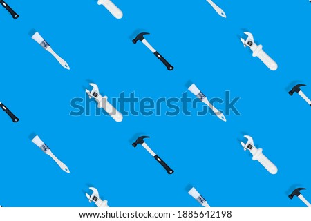 Tools seamless pattern. Tools: construction brushes, hammer, wrench on a blue background.