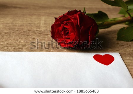 Red rose and white envelope with red heart. Gift for loved ones