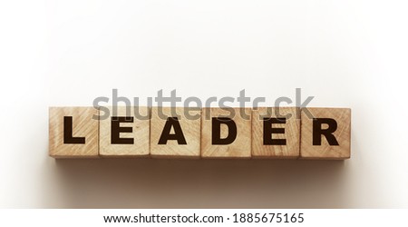 wooden cubes with text Leader written in black on a wooden block surface. Business concept.