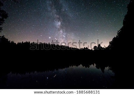 Germany, Black Forest Schwarzwald reflecting lake water under millions of stars of the milky ways galaxy by night in summer night