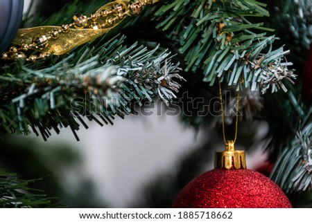 Horizontal Christmas card 2021, 2022. Red ball with diamonds. Copy-space for companies and individuals. Greeting card with bokeh background, colours red, green, gold, white, black.