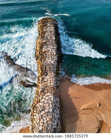 Aerial view from a stone jetty. Stone wave breaker blocks to protect the coast from erosion