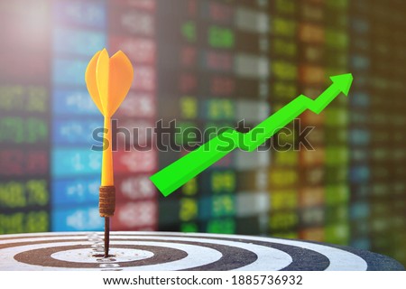target dart with arrow over blurred stock share chart background, image for target marketing concept.
