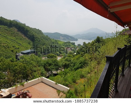 This is a picture of a landscape where a river and a mountain harmonize in a tall structure in a forest.