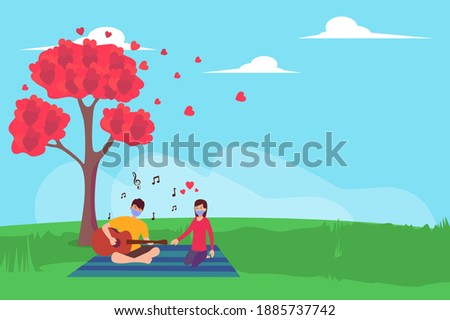 Couple in face mask playing guitar while singing together at the park