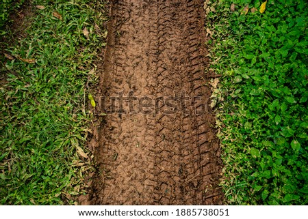 Tyre track on dirt sand or mud, Picture in retro or grunge tone. Car drive on sand. off road track. Track on grass field. Track in farm. Royalty-Free Stock Photo #1885738051