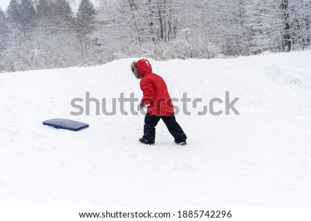 a boy rides on an ice rink from a snow slide