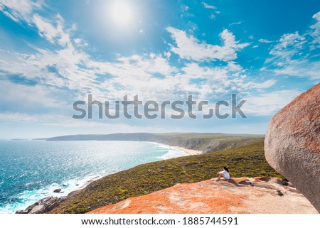 Woman sitting on the edge of the cliff at Remarkable Rocks on Kangaroo Island, South Australia