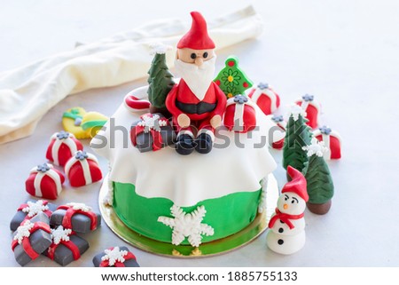 Christmas cake prepared with sugar paste. With santa claus, Christmas tree and gift figures on it