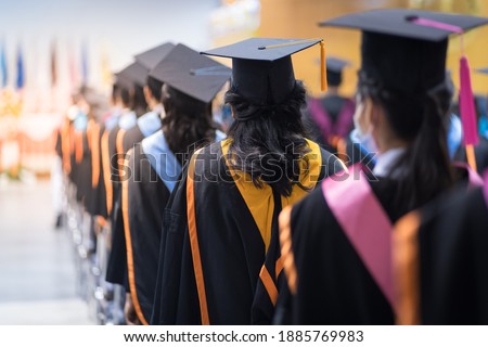 Rearview of the university graduates line up for degree award in university graduation ceremony. The university graduates are gathering in the university graduation ceremony. The crowd of the graduate Royalty-Free Stock Photo #1885769983