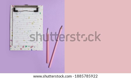 notepad with a pencil for writing text. on a pink and lilac paper background. Copy the space. concept back to school, a letter to Santa Claus, congratulation with Valentine's day