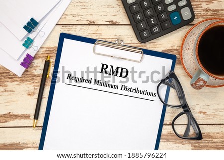 Paper with Required Minimum Distributions RMD on a table, calculator and glasses