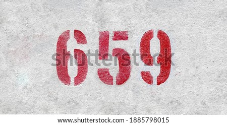 Red Number 659 on the white wall. Spray paint.