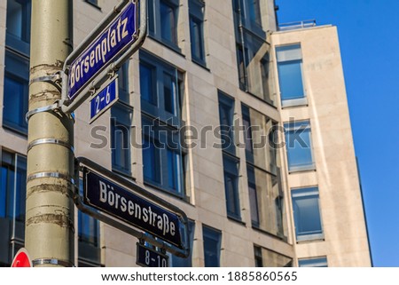 Two blue street signs stock exchange place and stock exchange street on a gray lamppost with fixings. House with window facade in the background