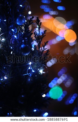 Christmas tree decorated with toys in the dark on the background of the lights of the night city