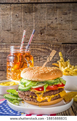 Celebrating Independence Day, July 4. Traditional American Memorial Day Patriotic Picnic with burgers,  french fries and snacks, Summer USA picnic and bbq concept, Old wooden background 