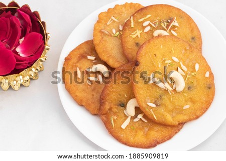 Creamy Indian Mithai Dessert Mawa Malpua Loaded With Khoya And Ghee And Topped With Nuts Dry Fruits Served In Plate With Rose Petals Decoration. Isolated On White Background With Copy Space For Text