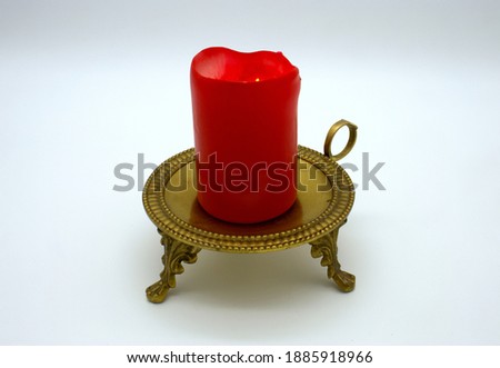 a picture of a red candle on a candleholder