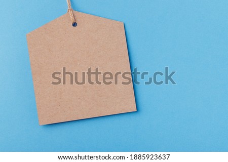 Empty mockup brown paper tag tied with string. price tag on blue background