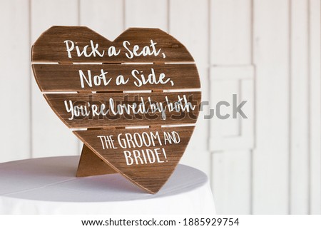 Shot of ceremony signage, pick a seat either side on a wedding day with a blurred background