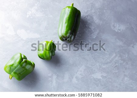 Ugly bell pepper on ultimate gray background. Deformed homegrown green bell pepper on the table. Non GMO vegetables. Top view