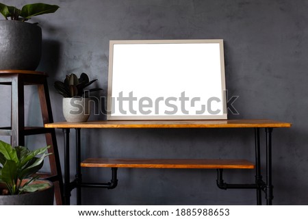 Square wooden frame with white mockup on vintage wooden table an modern tree pots with wall loft gray color backgroubd	