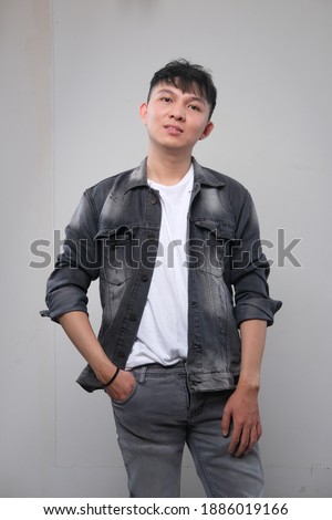 concept fashion photography southeast asian young male posing with black or white t-shirt and denim jacket.