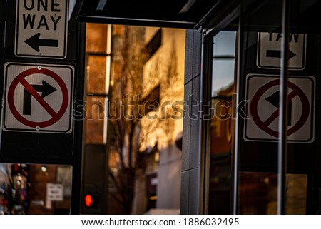 Image of a one way sign and reflection.