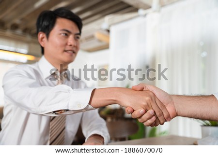 Medium close up shot of Asian Business man shake hand, Selective focused on the hands, Trusted and Renew contract concept.