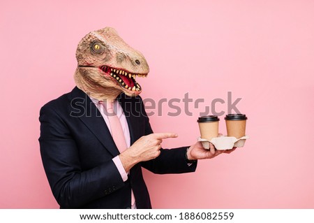 Man with lizard head holding two recyclable cardboard coffee cup.